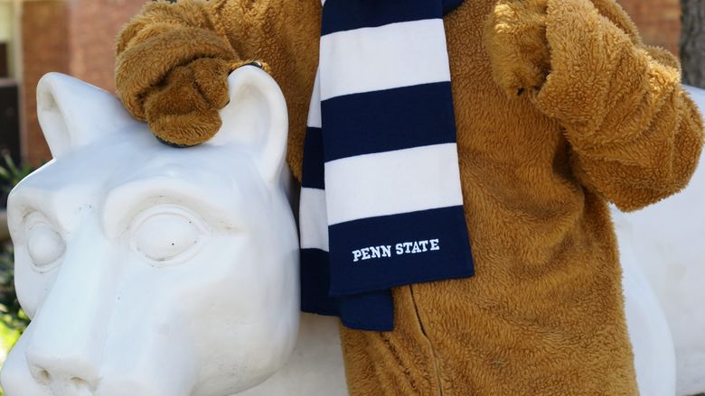 The Nittany Lion mascot poses for a photo at the Campus Lion Shrine