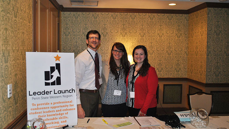 Three campus staff standing at the Leader Launch registration table