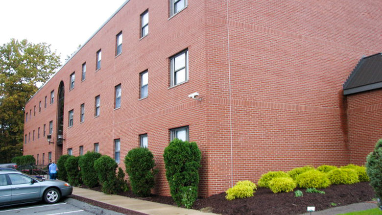 The red brick building exterior and well maintained landscaping