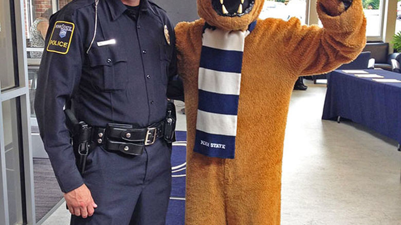 Public Safety Manager, Wesley Sheets poses with the Penn State New Kensington lion mascot at the entrance to the Athletic Center