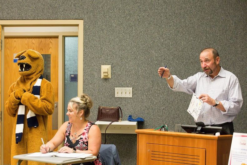 Art auctioneer calls for bids at the 2018 Off the Wall pARTy's art auction as mascot looks on Art auctioneer calls for bids at the 2018 Off the Wall pARTy's art auction as mascot looks on