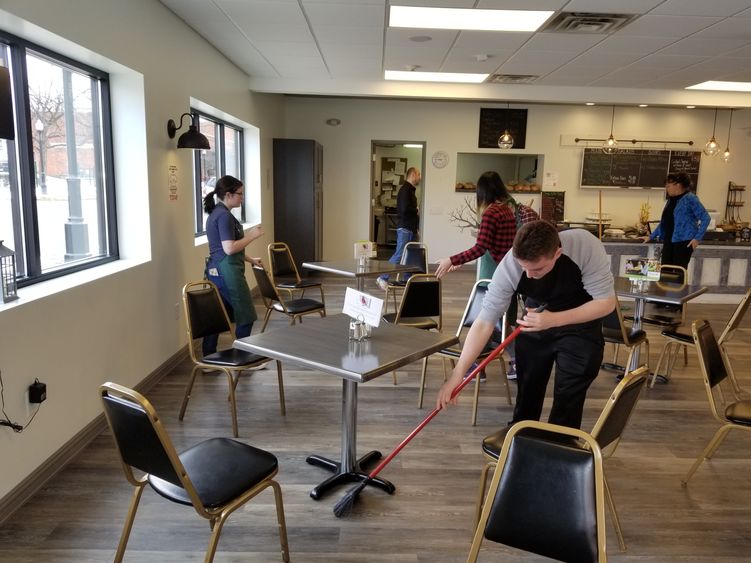 Students sweep floors and clean area of Knead Cafe Students sweep floors and clean area of Knead Cafe