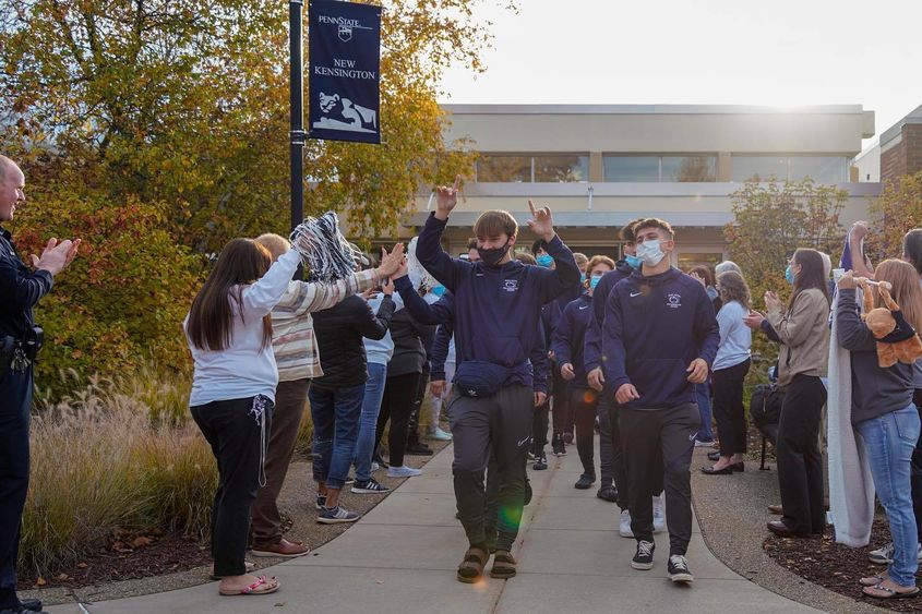 Men's soccer team walks through cheering crowd