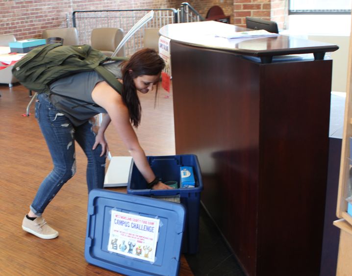 Student donating canned goods Food drive