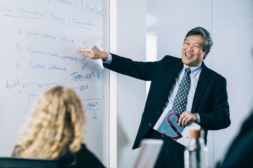 Instructor points to whiteboard as he teaches class