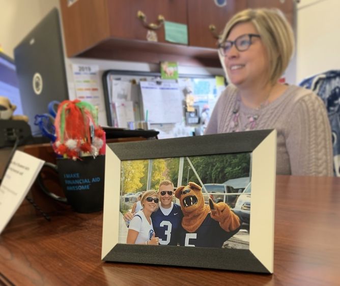 Framed photo of male and female smiling on desk with woman working in background