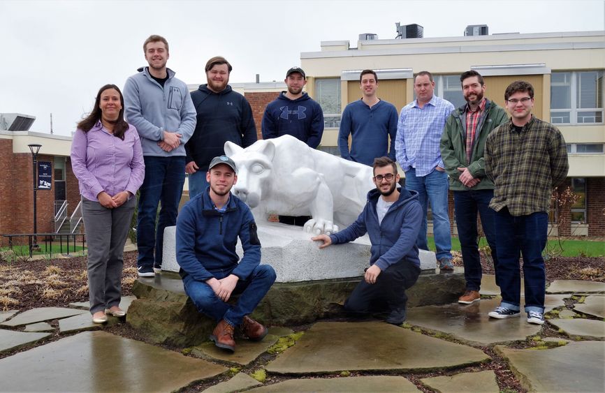 Penn State New Kensington BET students and faculty member stand by lion statue