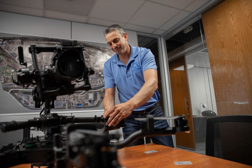 Man touching drone on table