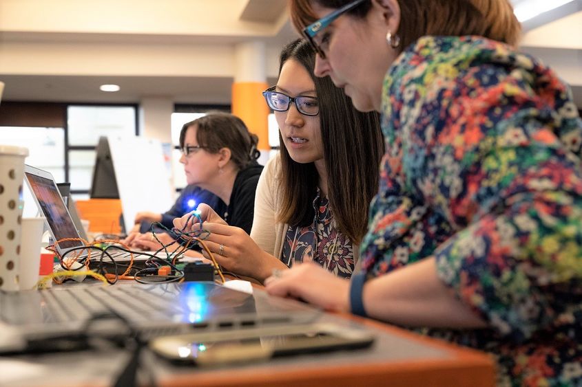 Two women work with Hummingbird Duo robotics kit