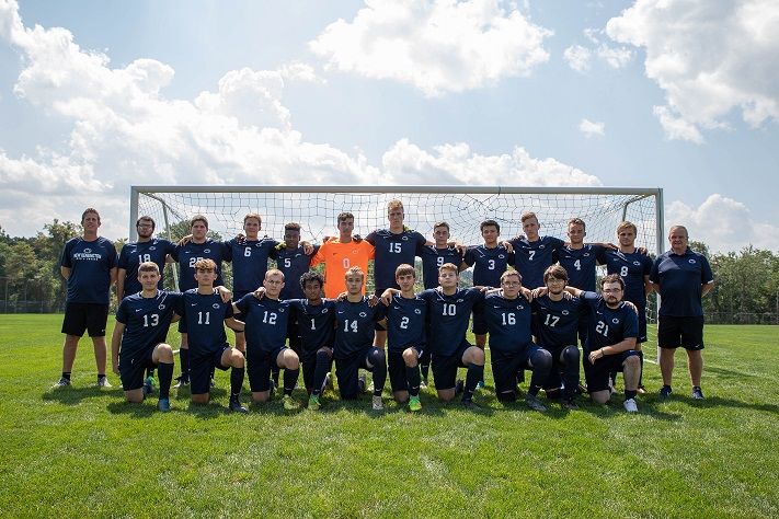 Soccer team stands in front of net for photo