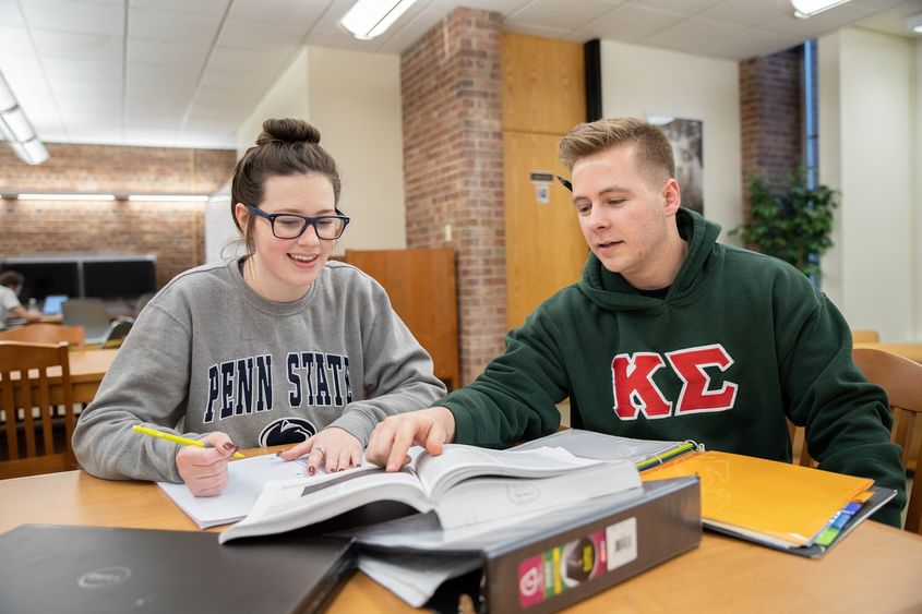 Julia Westerman and Brandon Fello sit in library