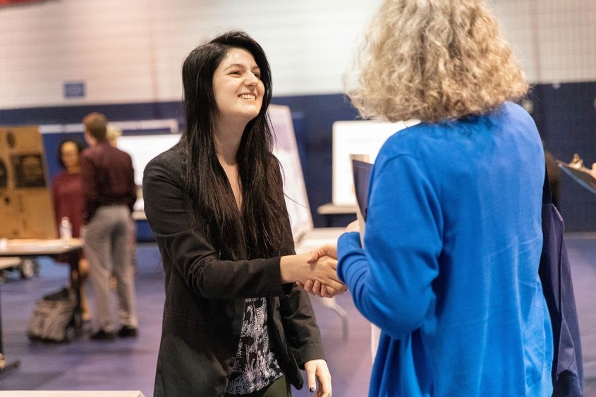 Two females shake hands