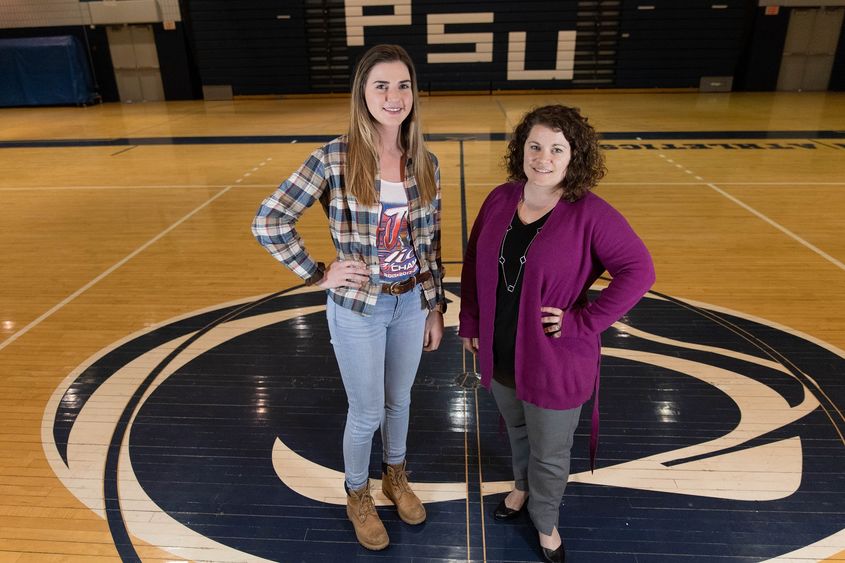 Two women standing in middle of gymnasium floor