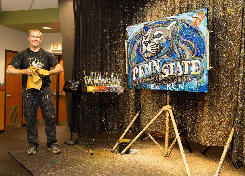 Man stands next to painting