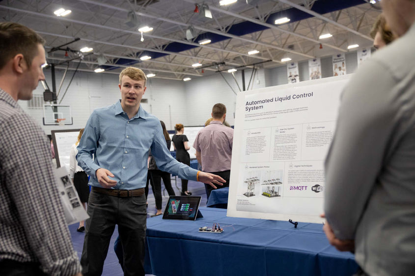 Student presents research project at table