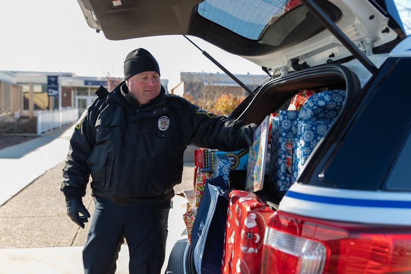 Police officer puts gift in car