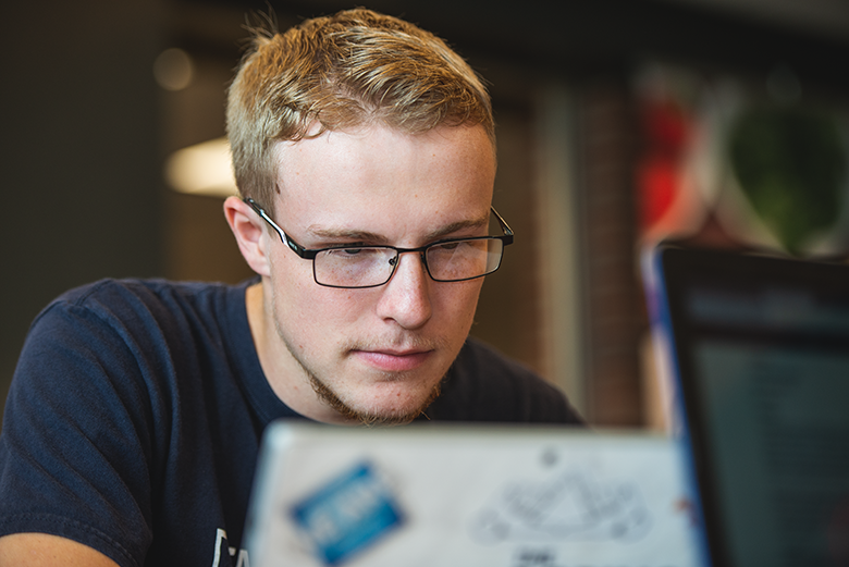 Male student looking at laptop Male student looking at laptop