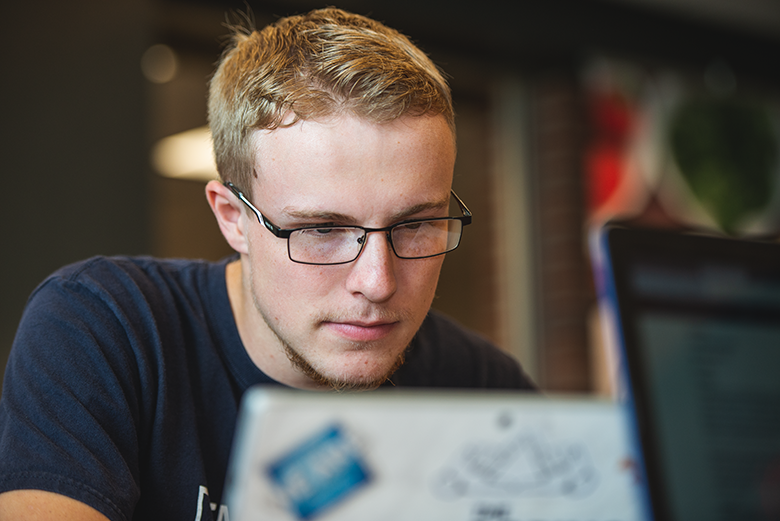 Male student looking at laptop