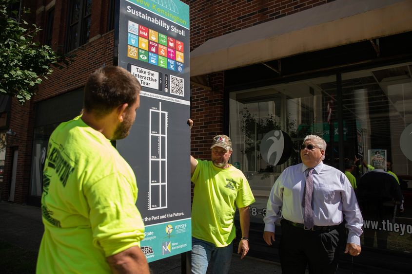 Three men look at street sign