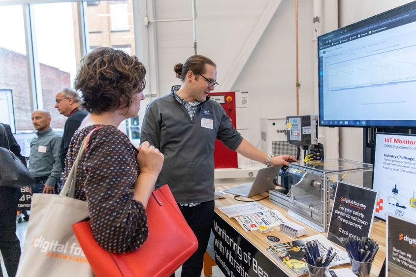 Man demonstrates technology to event attendee