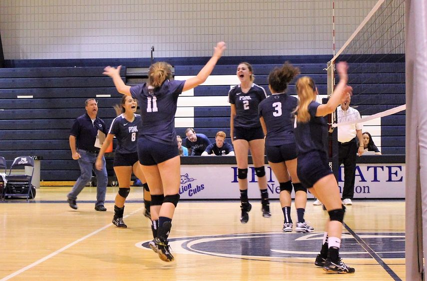 New Kensington volleyball team members jump in celebration